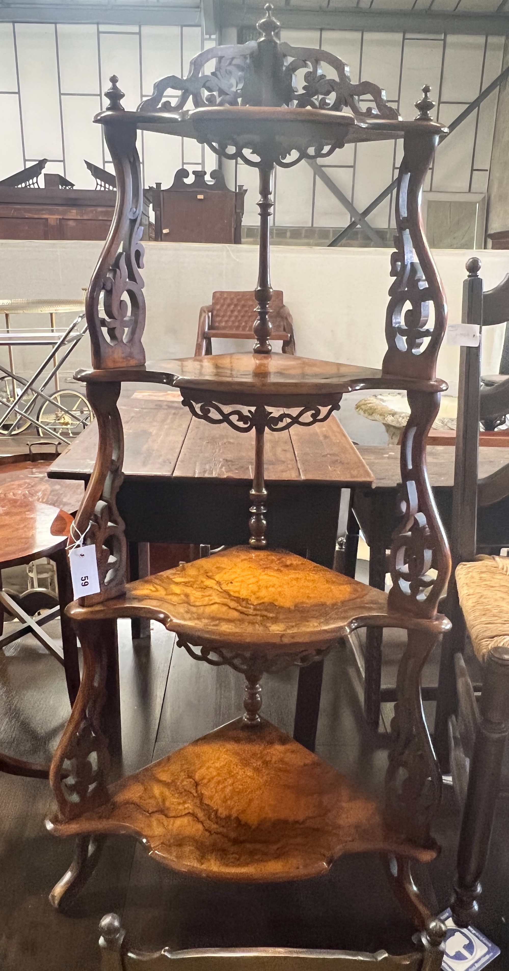 A Victorian figured walnut four tier corner whatnot, with graduated bowfront shelves and foliate scroll supports, width 59cm depth 37cm height 126cm